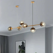 Modern brass and black art glass ball chandelier with six smoked glass globes for living room lighting