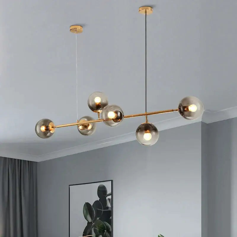 Modern brass and black art glass ball chandelier with six smoked glass globes for living room lighting