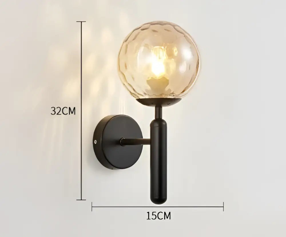 A sleek black wall sconce with a textured amber glass globe.
