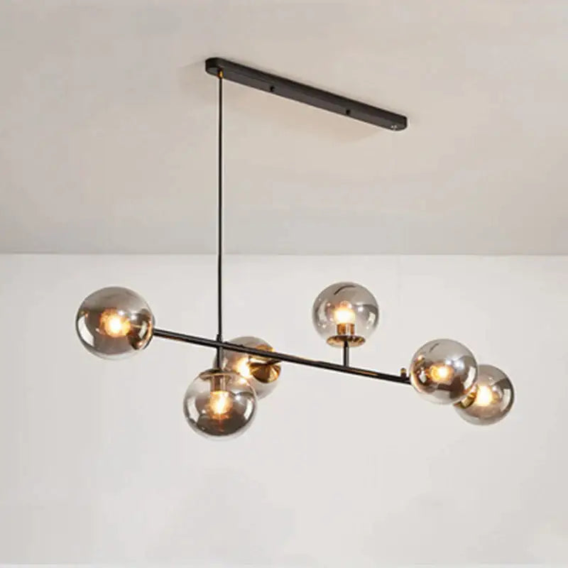Modern brass and black art glass ball chandelier featuring six smoked glass globe bulbs in black art finish for living room lighting