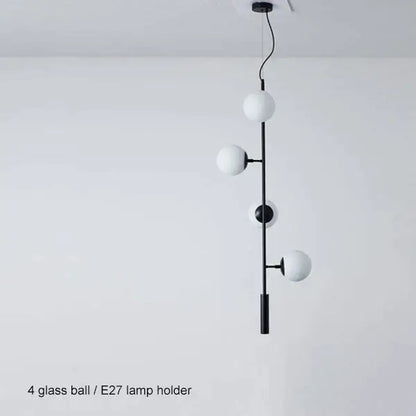 Modern black metal pendant light with four frosted glass spheres featuring black art glass ball design for living room