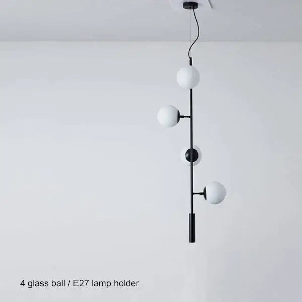 Modern black metal pendant light with four frosted glass spheres featuring black art glass ball design for living room