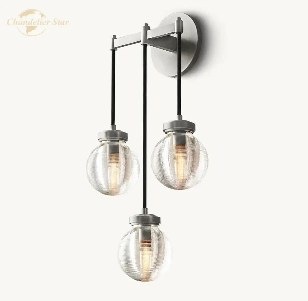 Modern brass and black crystal led wall sconce with brushed metal frame and textured clear glass globe shades for bedroom
