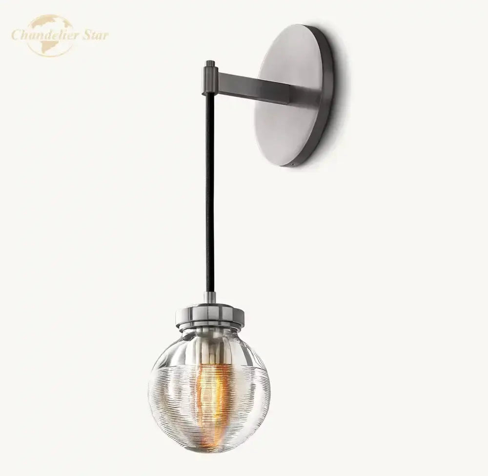 Modern brass and black crystal led wall sconce with brushed nickel base, black arm, and ribbed glass shade for bedroom lighting