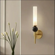 Modern brass and black decorbites foyer hallway lamp with frosted glass cylinder and black spherical accent wall sconce