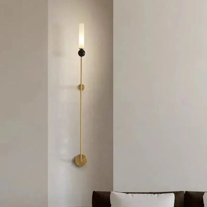 Modern brass and black decorbites foyer hallway lamp featuring a gold-toned minimalist sconce with frosted glass cylinder