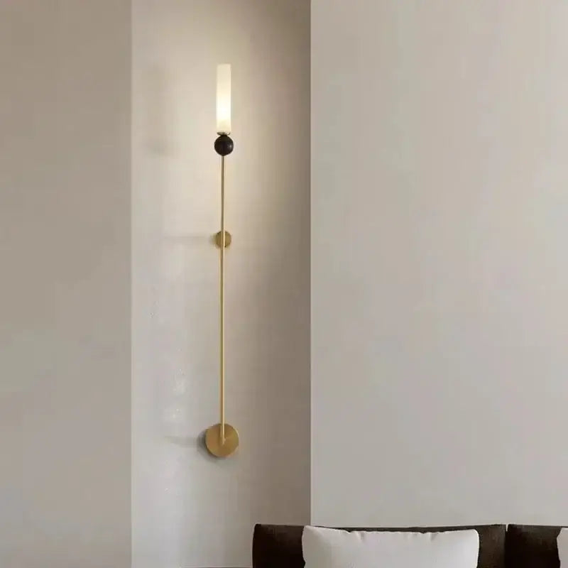 Modern brass and black decorbites foyer hallway lamp featuring a gold-toned minimalist sconce with frosted glass cylinder