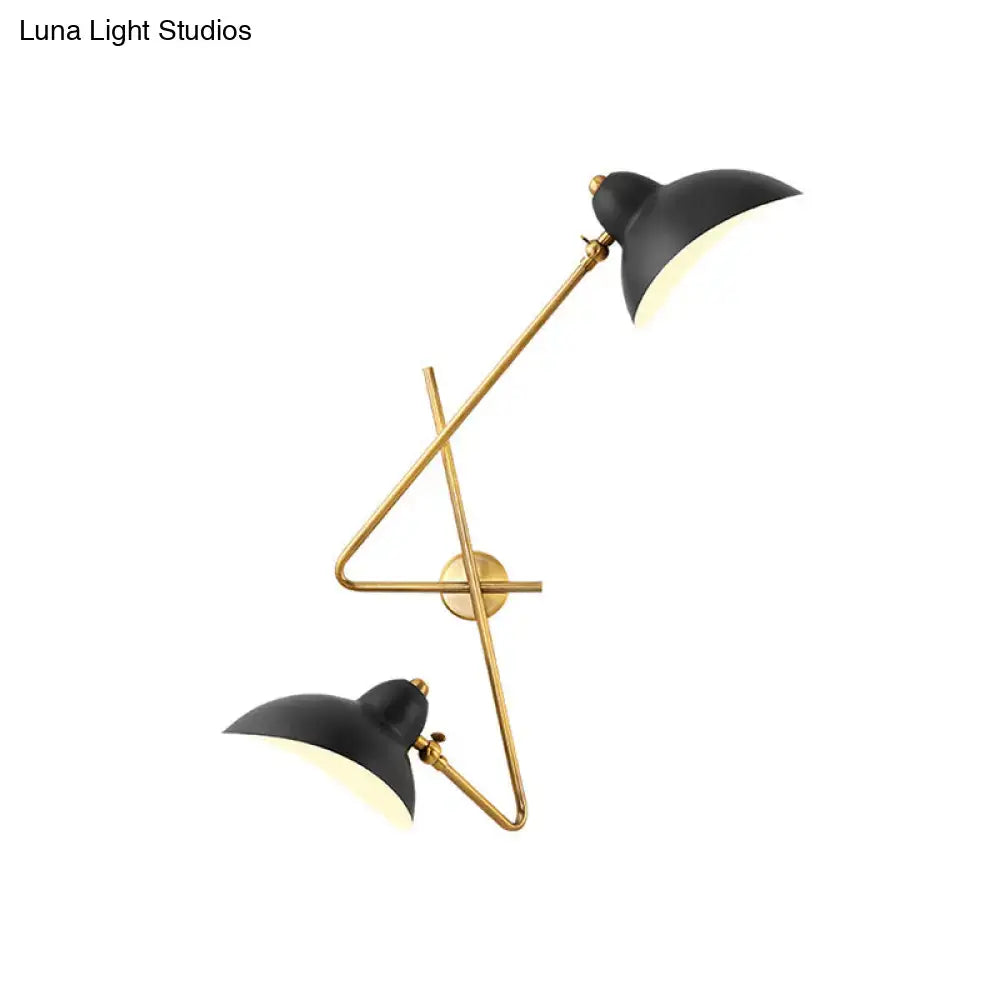 Modern brass and black metal duckbill wall sconce lamp with curved matte shades and angular cross-brace design for living room