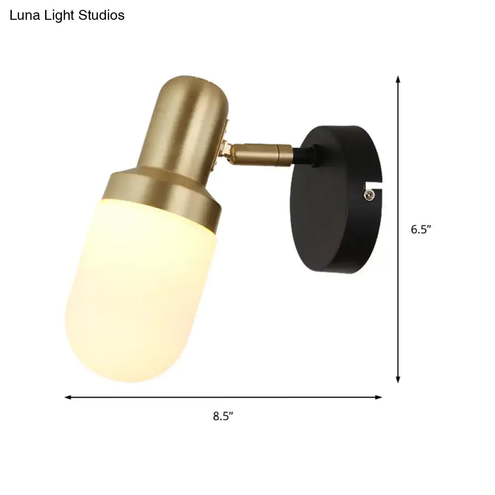 Modern brass and black glass sconce light with frosted glass shade and black mounting plate for bedroom walls