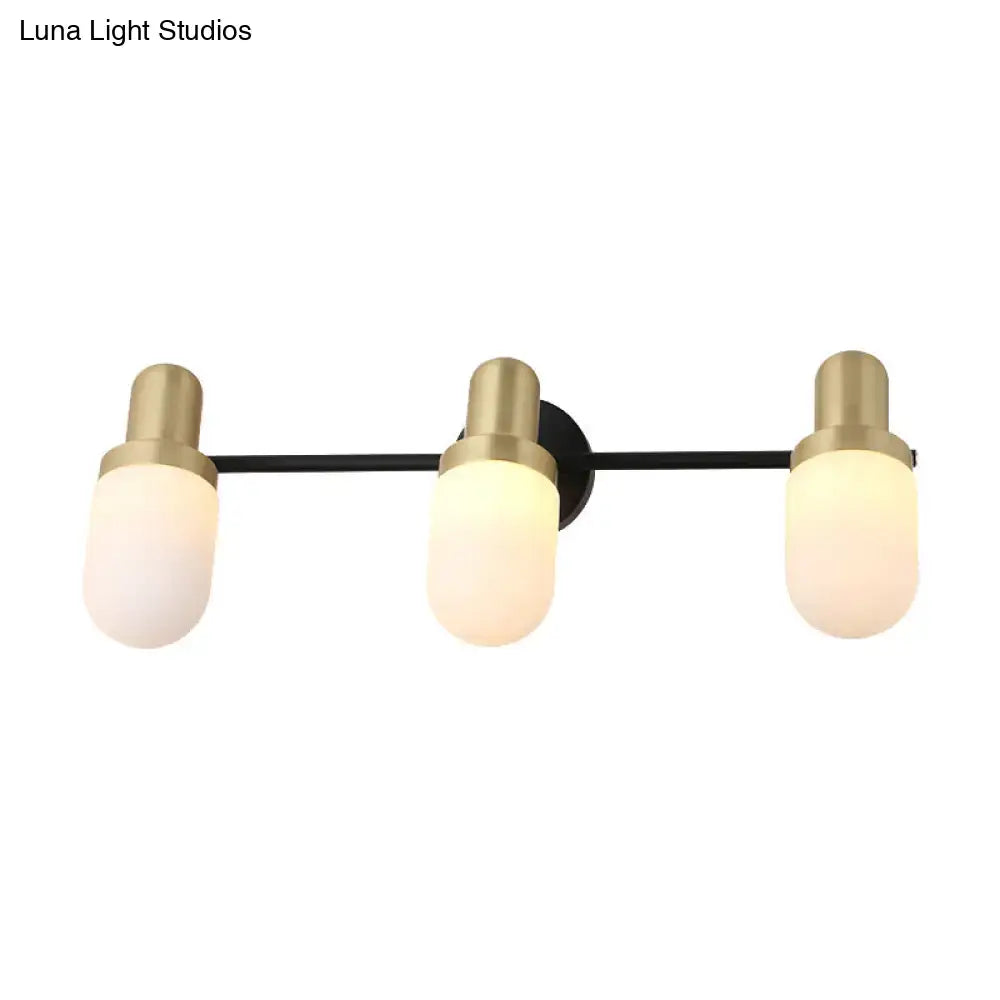 Modern brass and black glass sconce light with three frosted glass shades and brushed brass accents for bedroom wall lamp