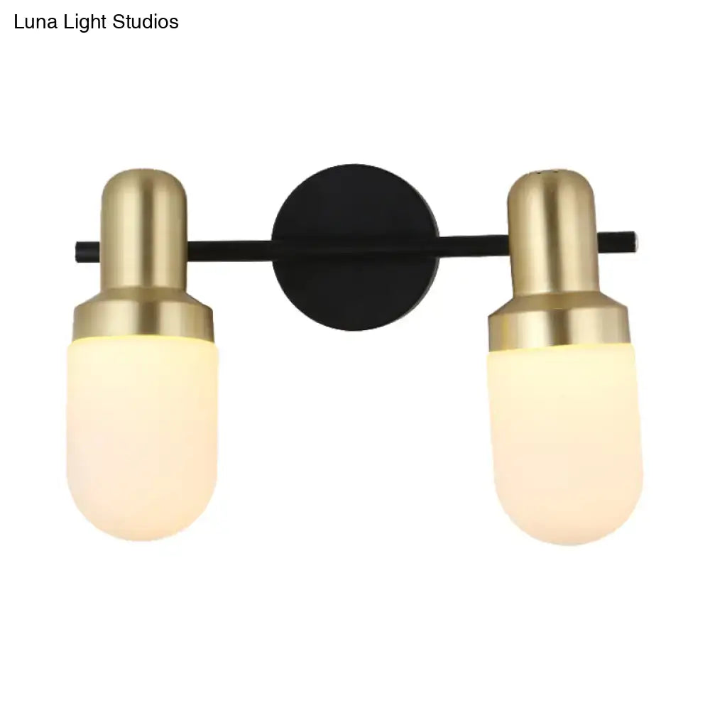 Modern brass and black glass sconce light with brushed brass fixtures and frosted glass shades on black metal bar