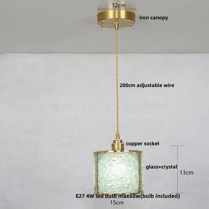 Modern brass and blue glass crystal led pendant light with cylindrical brass frame and intricate shade for kitchen use