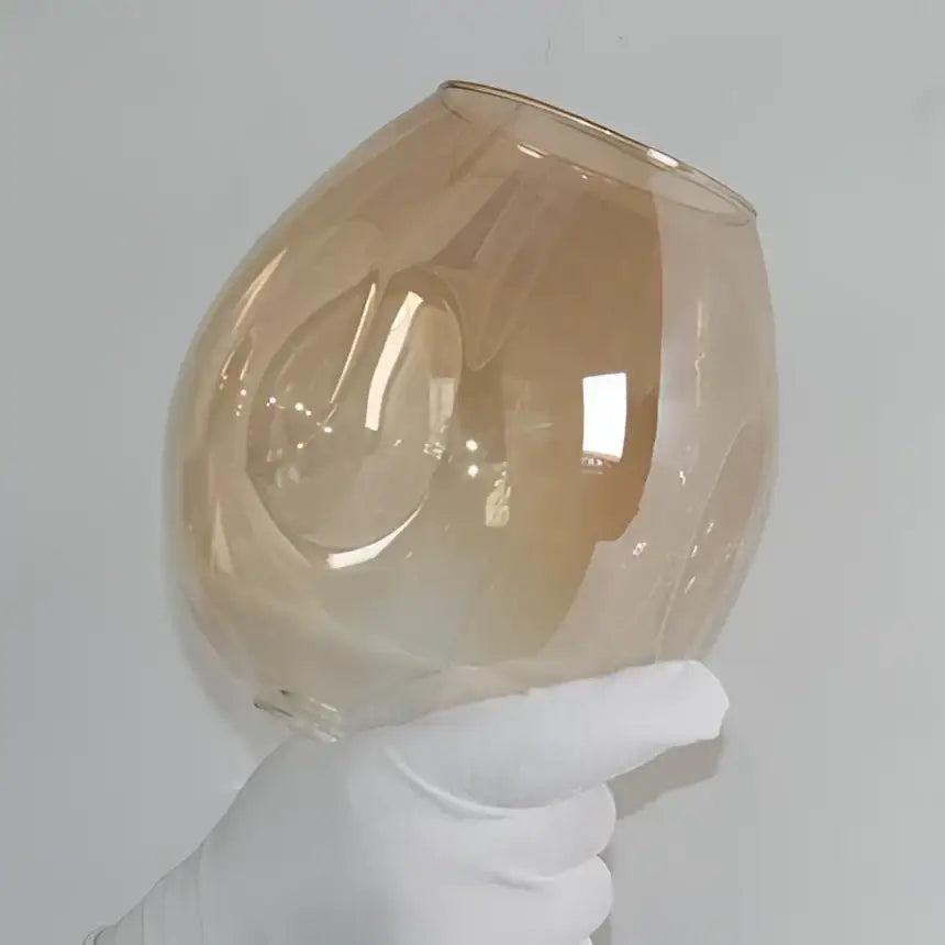 A translucent amber glass bowl with smooth shape complements modern brass and blue glass iron ball chandeliers