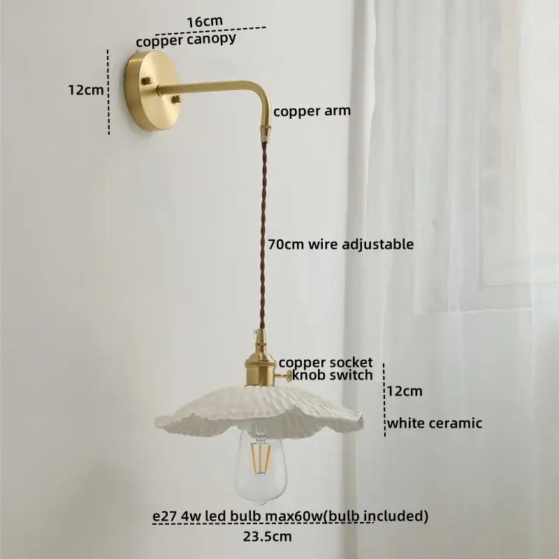 A delicate white ceramic copper led wall lamp with a fluted design hangs from an adjustable brass arm by decorbites