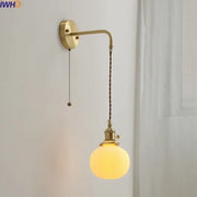 Modern brass and ceramic copper led wall lamp featuring a brass finish, twisted brown cord, and frosted glass globe bulb