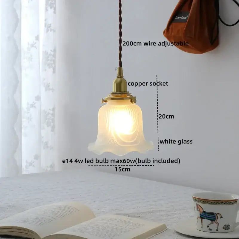 A warm glowing modern brass and clear glass chandelier pendant light with a white glass shade for dining room