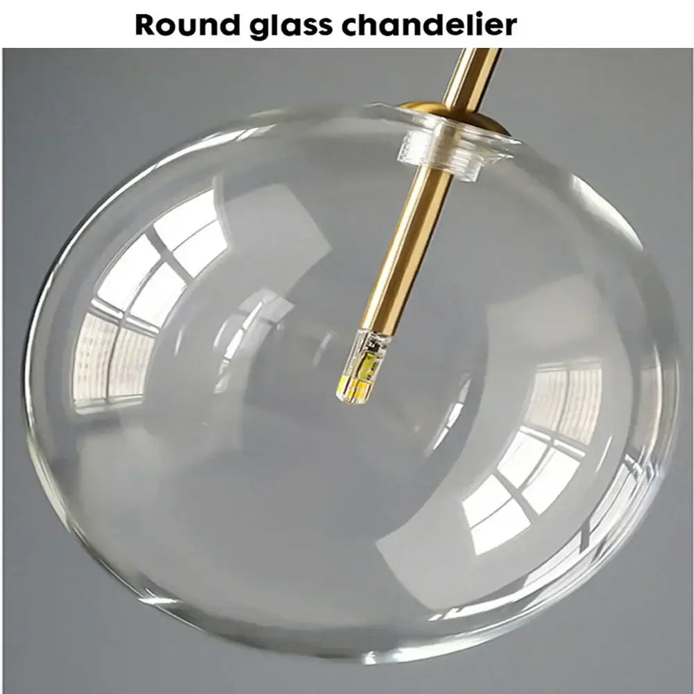 Modern brass and clear glass pendant light with a clear glass chandelier globe and gold-toned rod for dining room decorbites