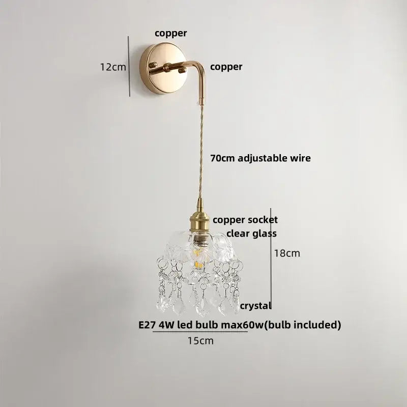 A delicate modern brass wall lamp with clear glass shade and dangling crystal droplets for bedroom decorbites clear glass
