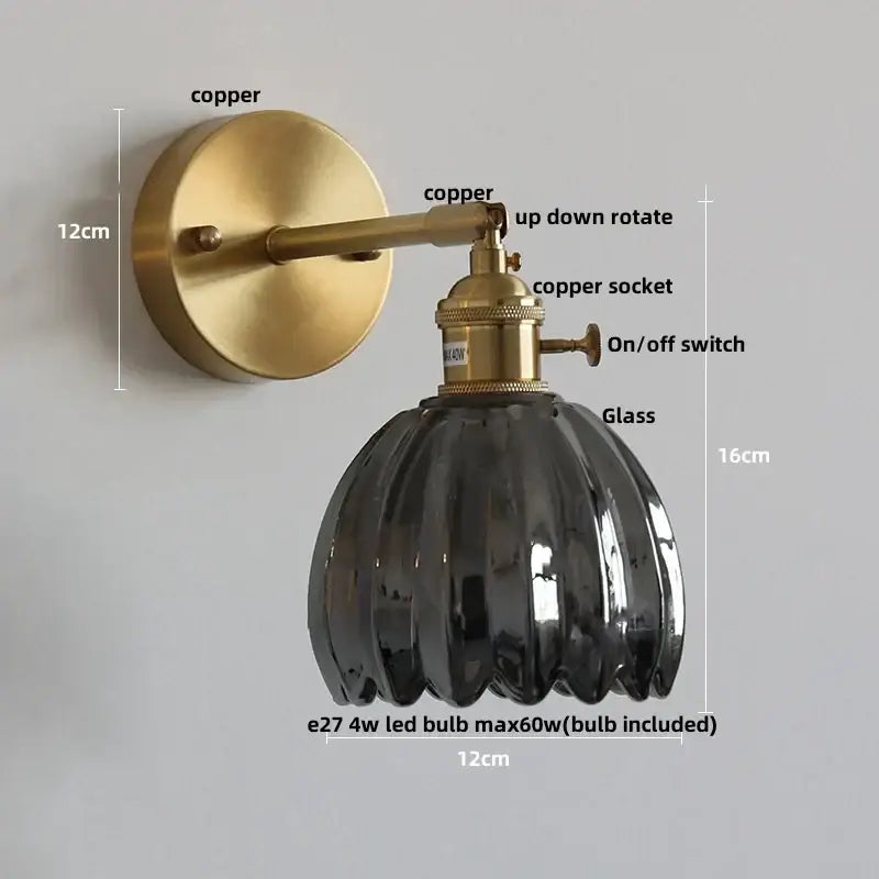 A modern brass and clear glass wall light with a sleek dark fluted lampshade on an adjustable copper arm by decorbites clear glass