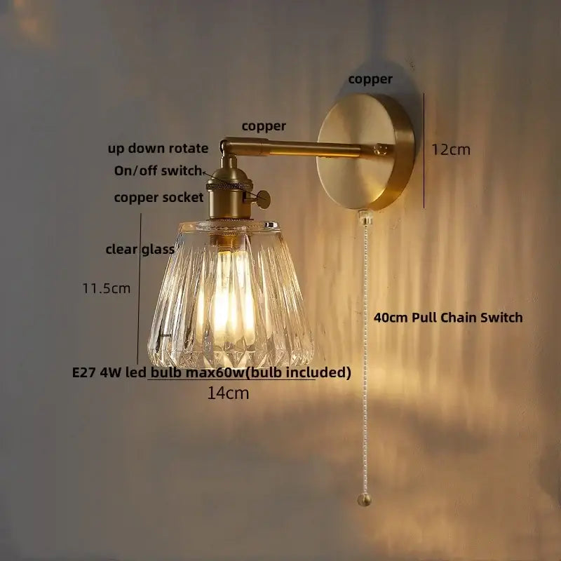 Modern brass and clear glass wall lights with a brass-finished copper arm and clear glass decorbites shade for bedroom sconce