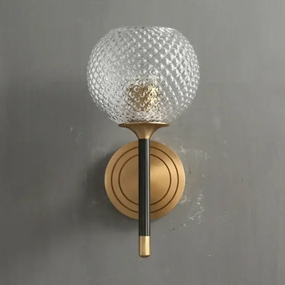 A modern brass and copper wooden wall light with a clear textured glass globe and copper wooden frame decorbites design