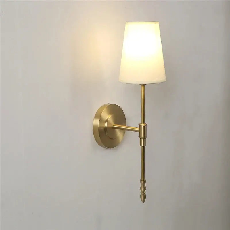Modern brass and cream fabric led wall lamp with brass finish and cream shade ideal for bedroom wall lamps