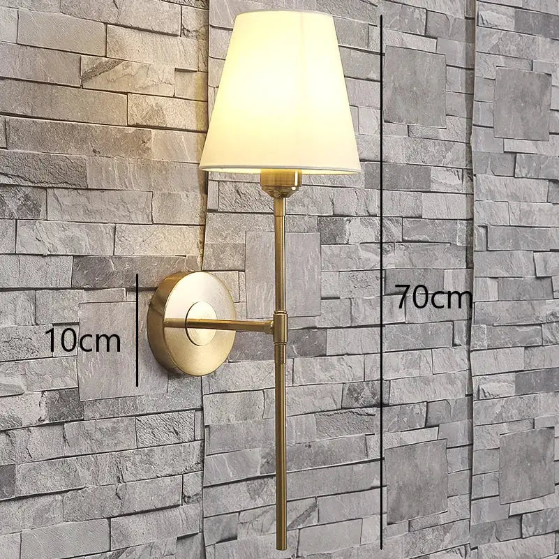 Modern brass and cream fabric led wall lamp with tapered off-white shade ideal for bedroom wall lamps lighting