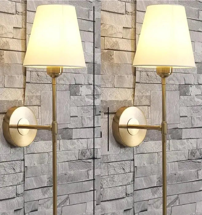 Modern brass and cream fabric led wall lamp with tapered off-white fabric shade for bedroom lighting