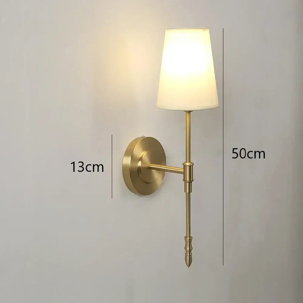 Modern brass and cream fabric led wall lamps featuring a brass-finished wall sconce with cream fabric shade for bedroom use
