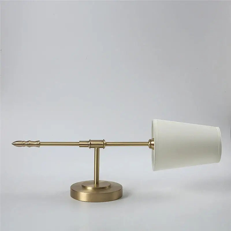 A sleek brass led wall lamp with a minimalist design and tapered cream fabric shade for modern bedroom use
