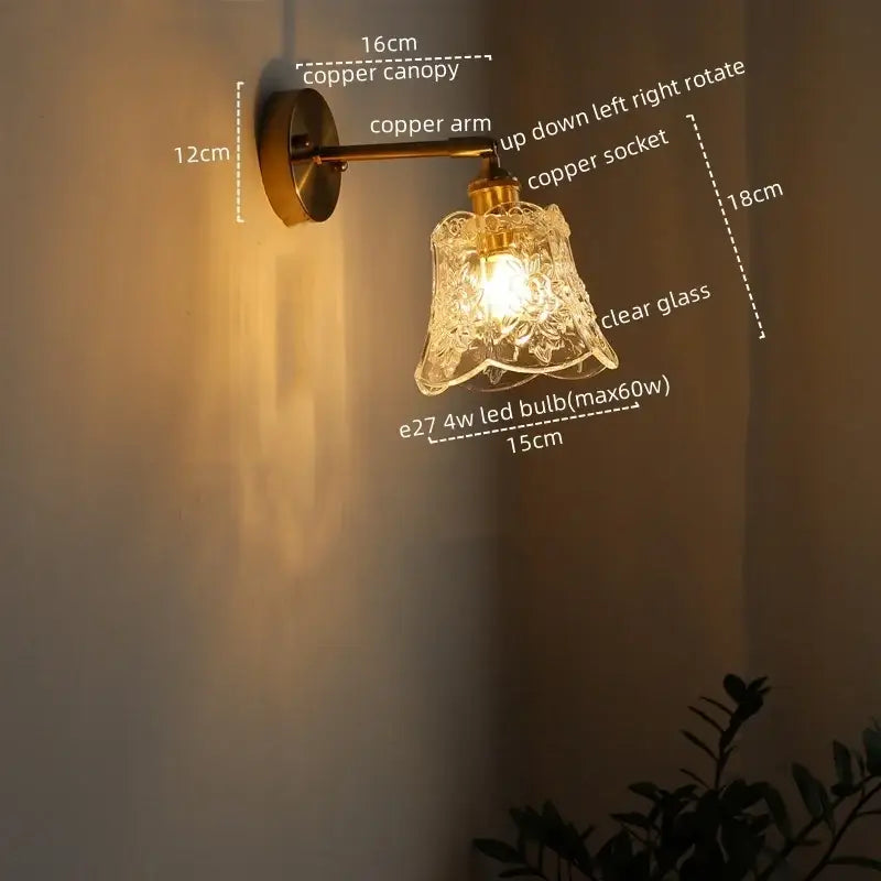 Copper wall sconce with clear glass shade and floral etching as modern brass and crystal led wall lamps for bedroom use