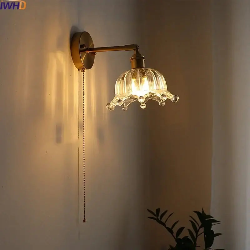 Modern brass and crystal led wall lamp with clear ribbed glass shade and dangling crystal beads for bedroom use