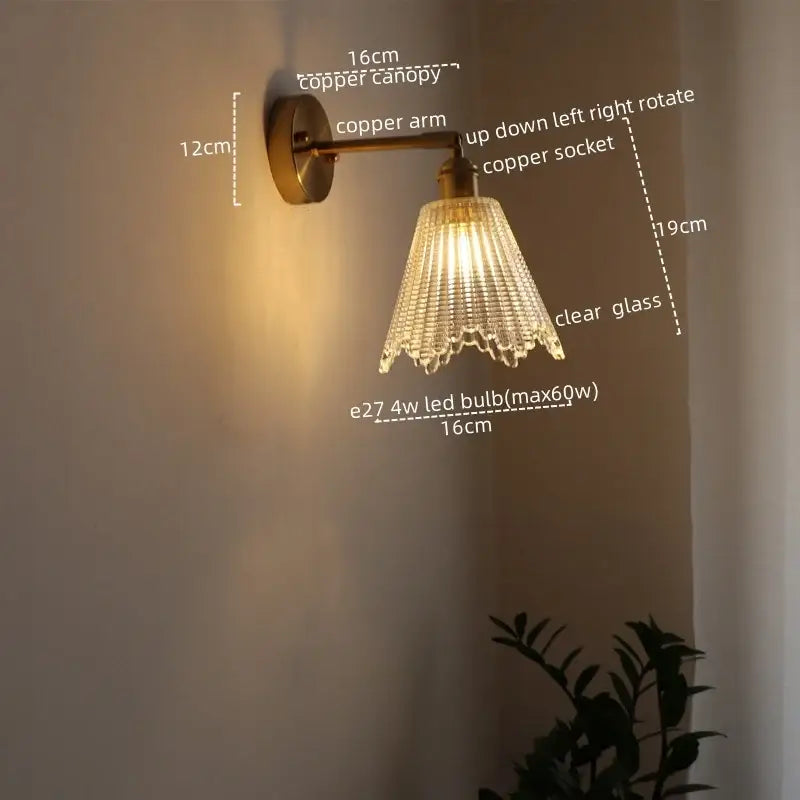 A vintage-style modern brass and crystal led wall lamp with copper-finished metal frame and clear faceted glass shade