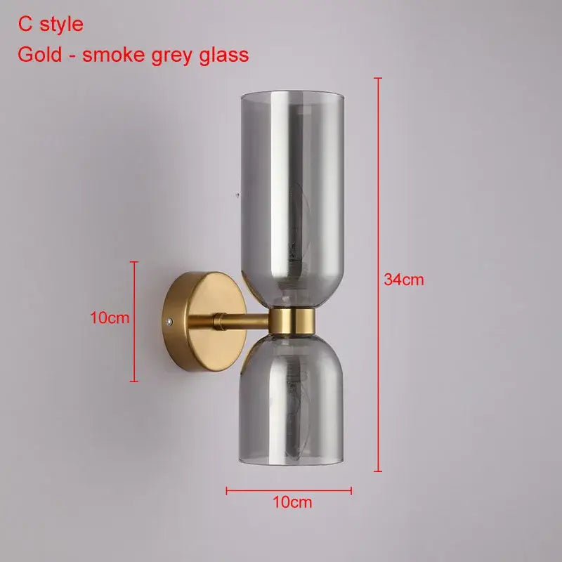 Modern brass wall lamps with gold finish and two smoked grey decorbites glass ball shades for bedroom sconces