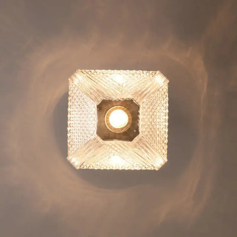 Modern brass and diamond glass pendant lamp with crystal-encrusted square fixture emitting warm glow for living room