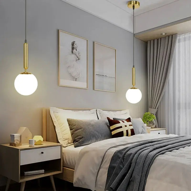 Modern brass and frosted glass ball pendant light with gold finish and spherical shades hanging above bed decorbites glass ball