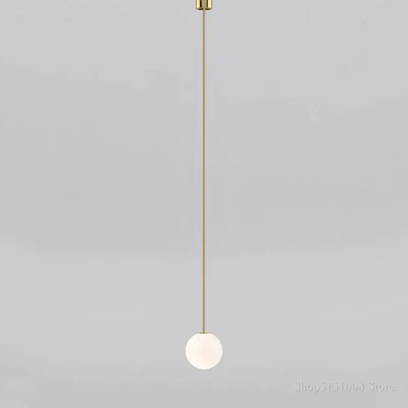 Minimalist modern brass pendant light with frosted glass ball and slender rod for elegant kitchen lighting decorbites glass ball