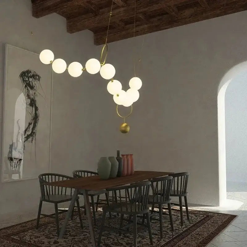 Modern brass and glass ball pendant light with white spherical glass balls and gold-toned metal rings for dining room decorbites glass ball chandelier