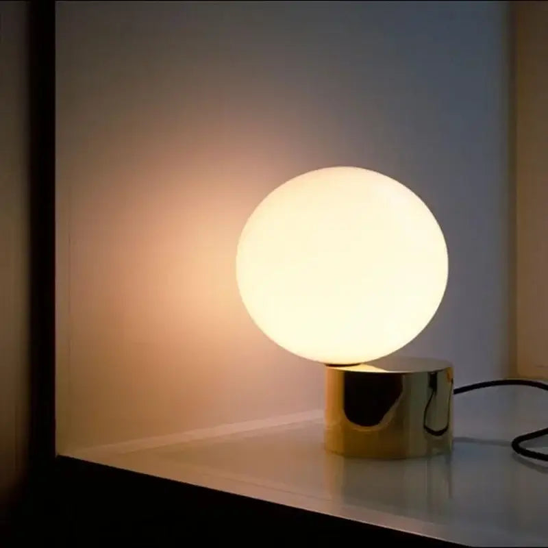 Modern brass and glass ball table lamp with glowing white glass ball globe on polished gold-toned base for bedside decorbites glass ball ball table lamp