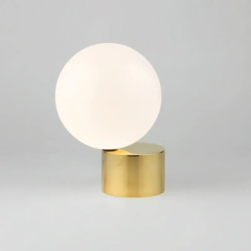 Modern brass and glass ball table lamp with frosted white glass globe on polished brass base for bedside decorbites glass ball