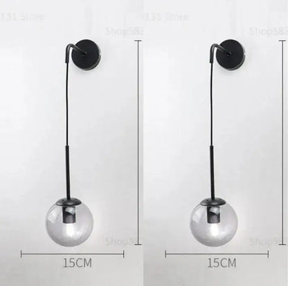 Modern black metal wall lamp with clear glass ball shade for bedroom decor featuring decorbites glass ball design