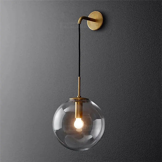 Modern brass and glass ball wall lamp with brass finish and clear glass globe for bedroom decorbites glass ball lighting
