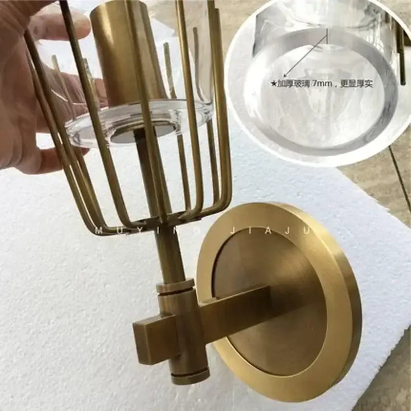 Modern brass and glass bedside table lamp wall sconce with clear glass shade encased in vertical metal bars