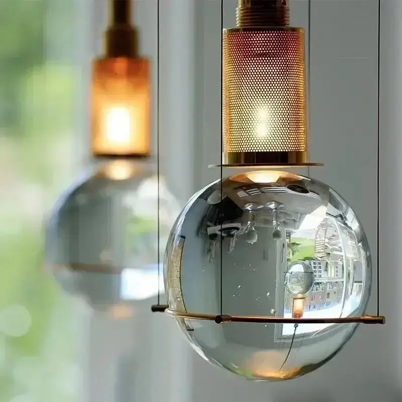 Modern brass and glass crystal ball led pendant light with a transparent globe and brass mesh top for dining room decorbites pendant light