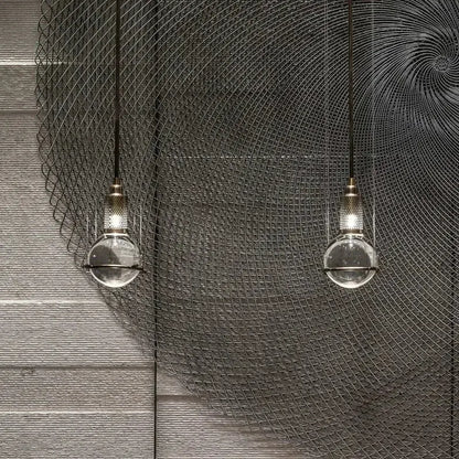 Modern brass and glass pendant light with crystal ball led bulbs hanging against a dark wire mesh backdrop decorbites crystal ball