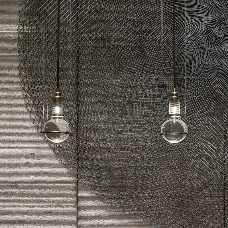 Modern brass and glass pendant light with crystal ball led bulbs hanging against a dark wire mesh backdrop decorbites crystal ball
