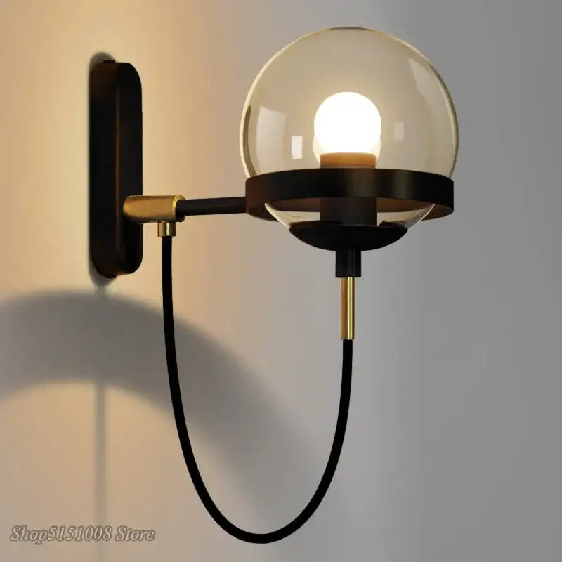 Modern brass and glass globe led wall lamp with black and brass sconce and spherical smoked glass globe for bedroom lighting