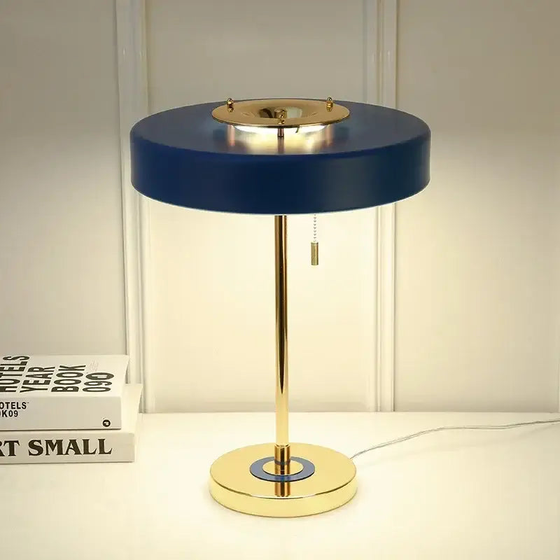A sleek navy blue and gold table lamp with polished brass base and circular shade from DecorBites Scandinavia lighting
