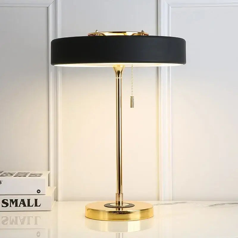 Black matte table lamp with gold-toned metal base and circular shade for decorbites scandinavia lighting led bedroom use