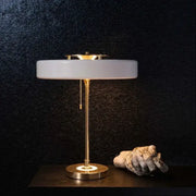 A sleek modern table lamp with frosted white glass shade and polished brass base for decorbites scandinavia lighting